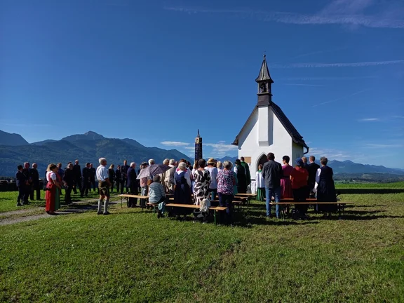 Die versammelten Kirchgänger vor malerischer Kulisse.